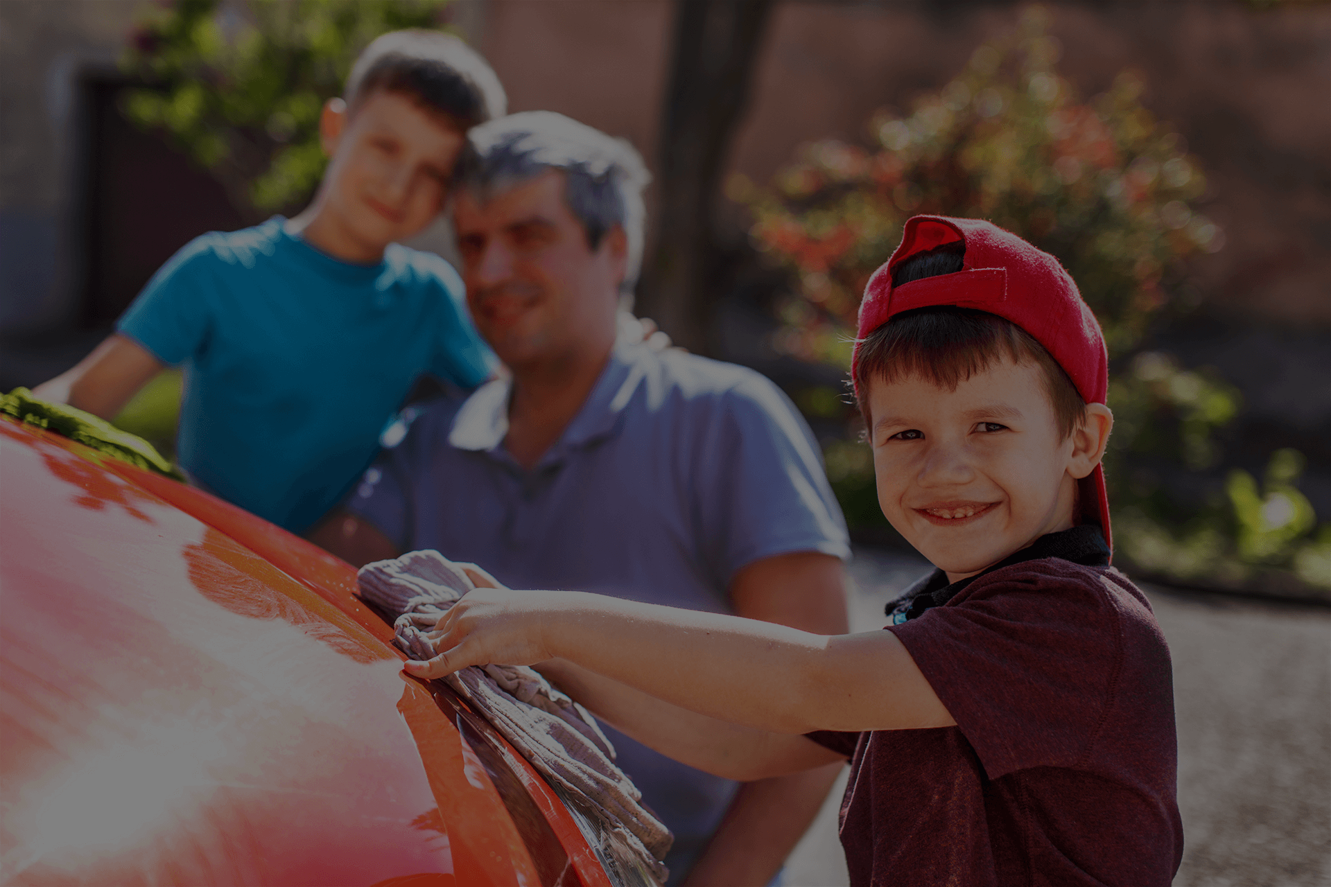 Dad washing car with sons